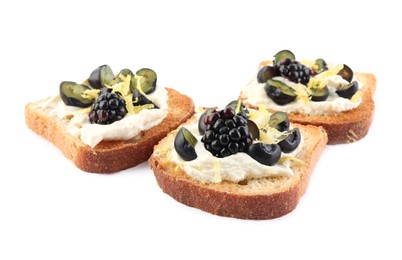 Photo of Tasty sandwiches with cream cheese, blueberries, blackberries and lemon zest on white background