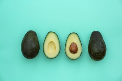 Photo of Tasty fresh avocados on turquoise background, flat lay