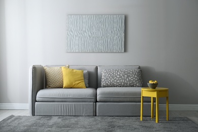 Stylish living room with sofa. Interior design in grey and yellow colors