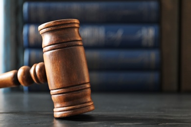 Wooden gavel on dark table, closeup. Law concept