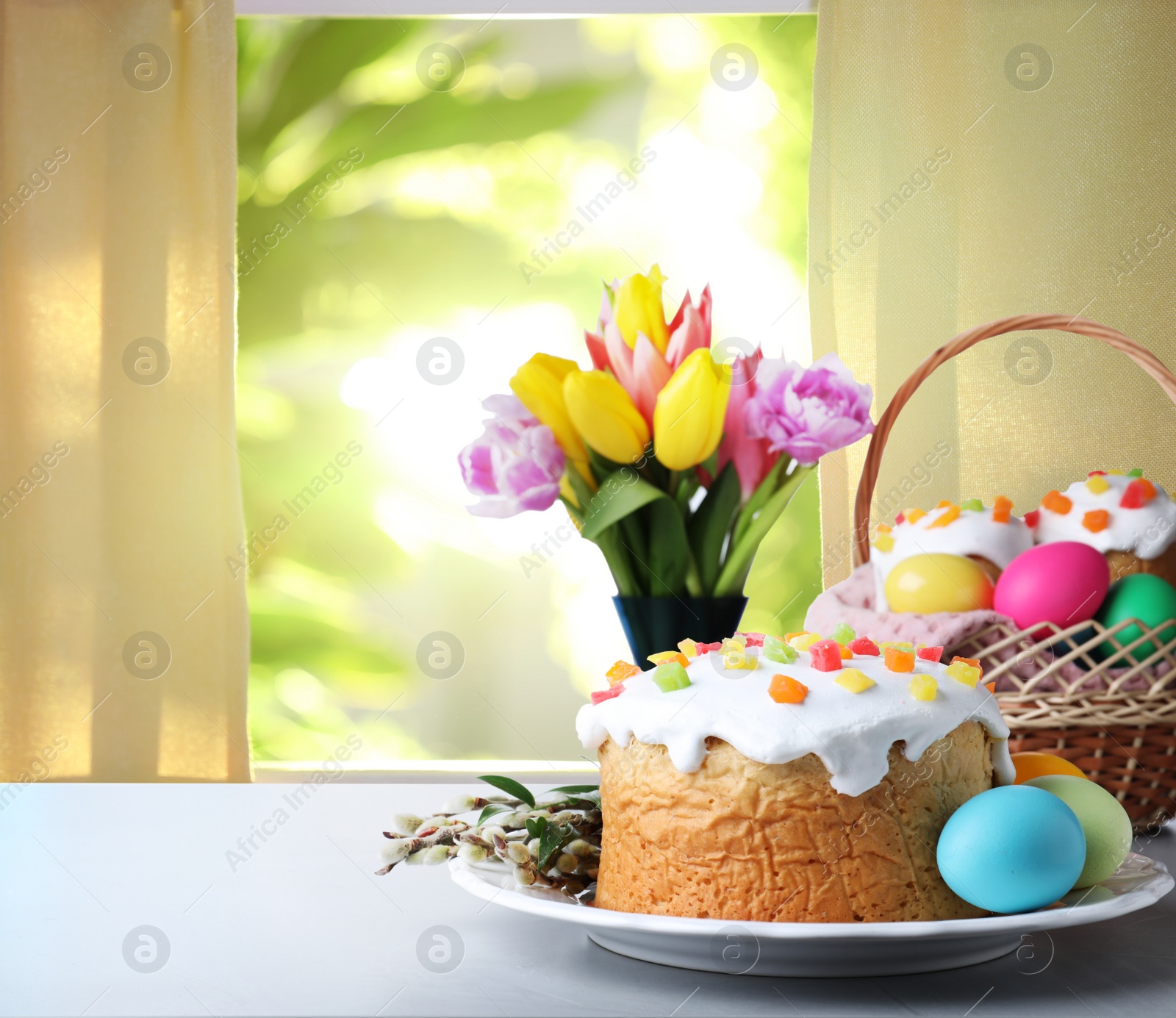 Image of Delicious Easter cakes and painted eggs on light grey table indoors. Space for text