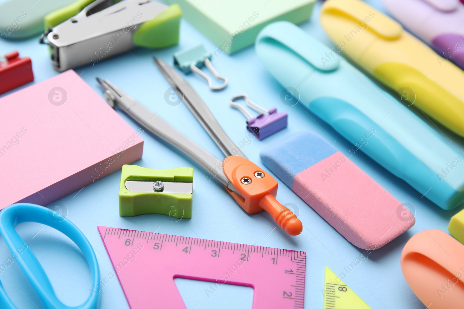 Photo of Many different school stationery on light blue background, closeup. Back to school