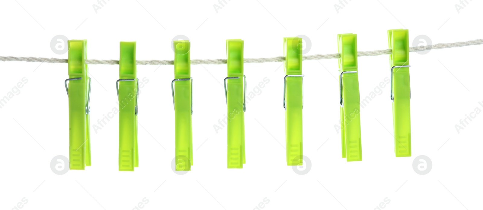 Photo of Bright green plastic clothespins hanging on rope against white background