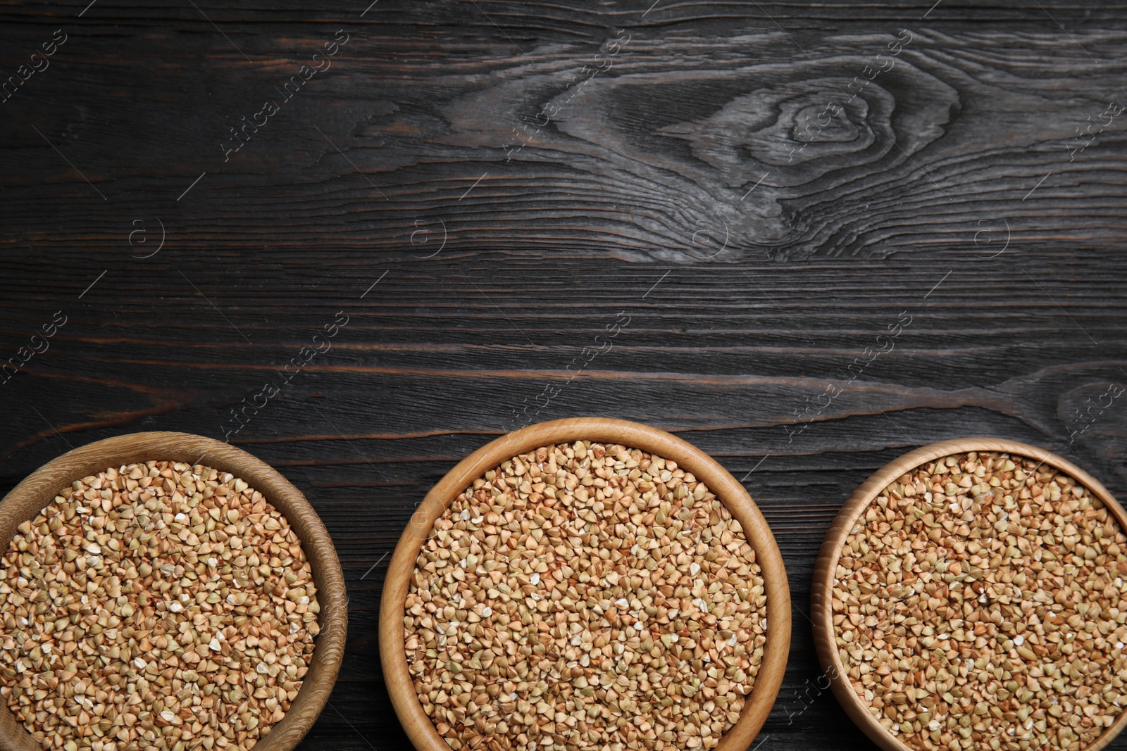 Photo of Flat lay composition with green buckwheat on black wooden table. Space for text