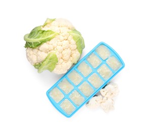 Cauliflower puree in ice cube tray and fresh cauliflower isolated on white, top view