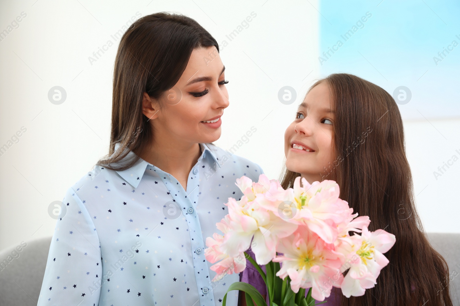 Photo of Little daughter congratulating her mom at home. Happy Mother's Day