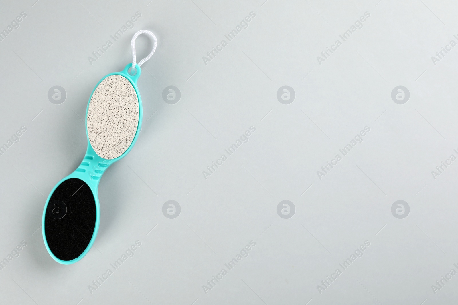 Photo of Pedicure tool with pumice stone and foot file on light grey background, top view. Space for text