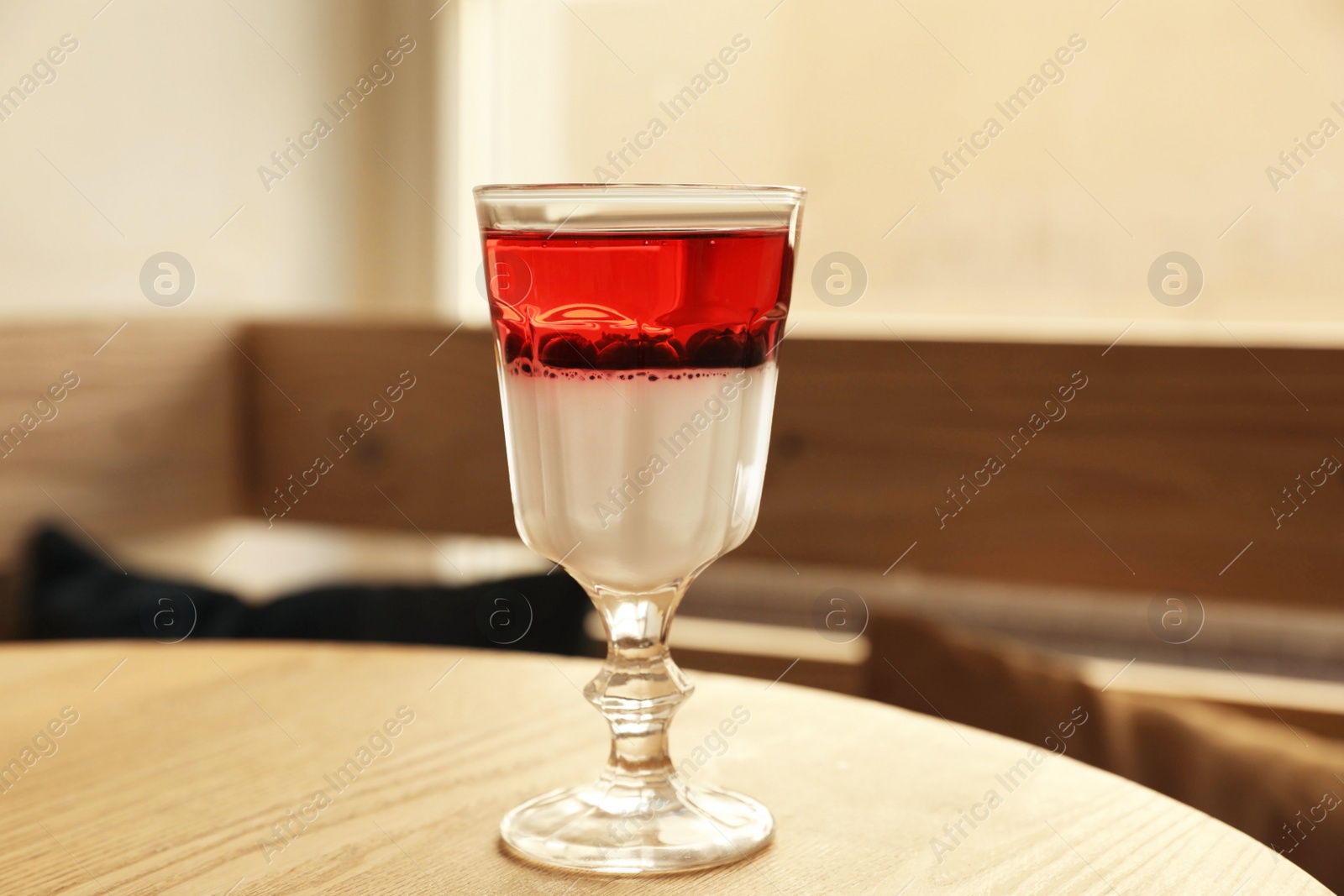 Photo of Delicious panna cotta dessert with berries on wooden table