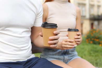 Photo of Coffee to go. Couple with paper cups outdoors, selective focus