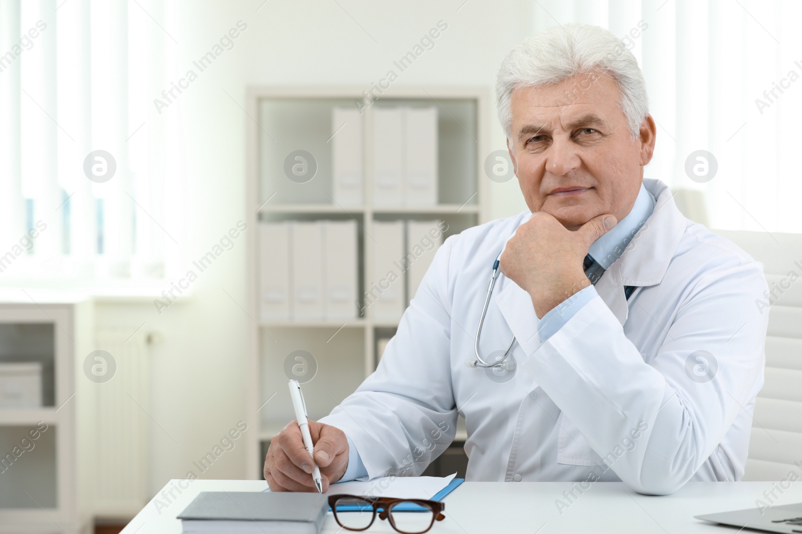 Photo of Portrait of senior doctor in white coat at workplace