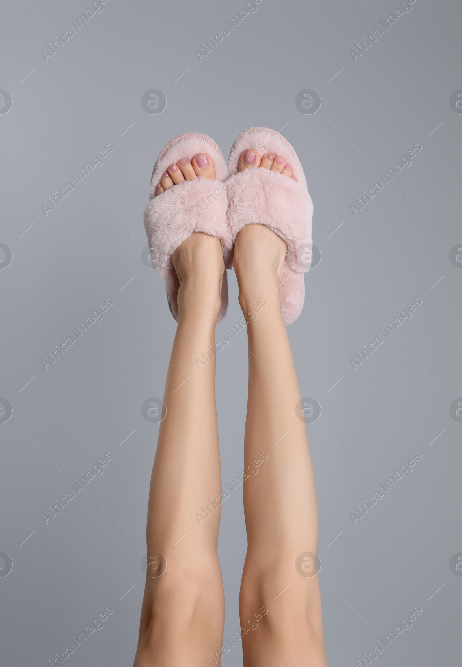 Photo of Woman wearing stylish slippers on grey background, closeup