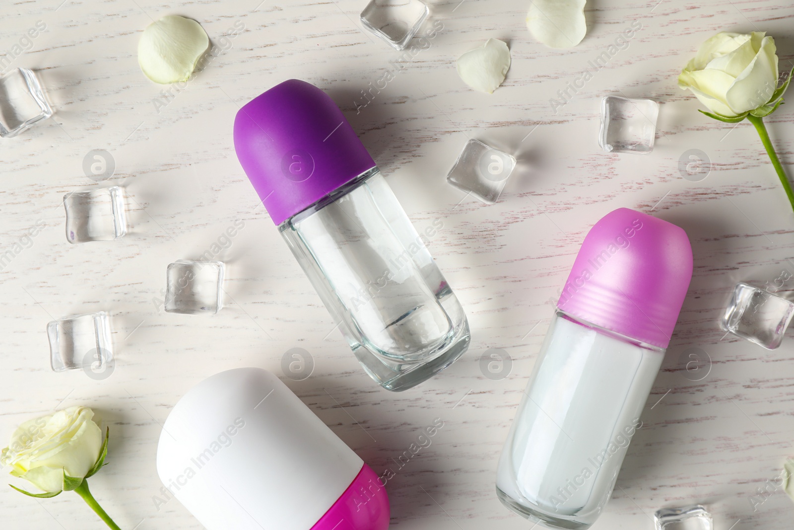 Photo of Flat lay composition with female roll-on deodorants on white wooden table