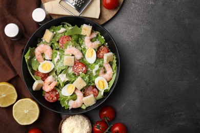 Delicious Caesar salad with shrimps and ingredients on brown table, flat lay. Space for text