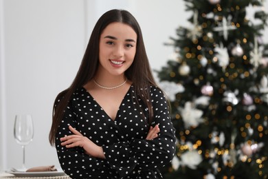 Photo of Portrait of happy woman near Christmas tree indoors