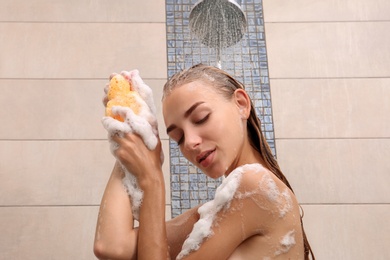 Beautiful young woman taking shower at home