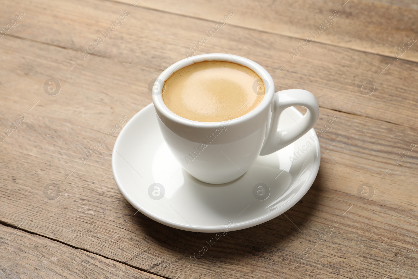 Photo of Aromatic coffee in cup on wooden table