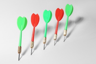 Photo of Bright color dart arrows for game on white background