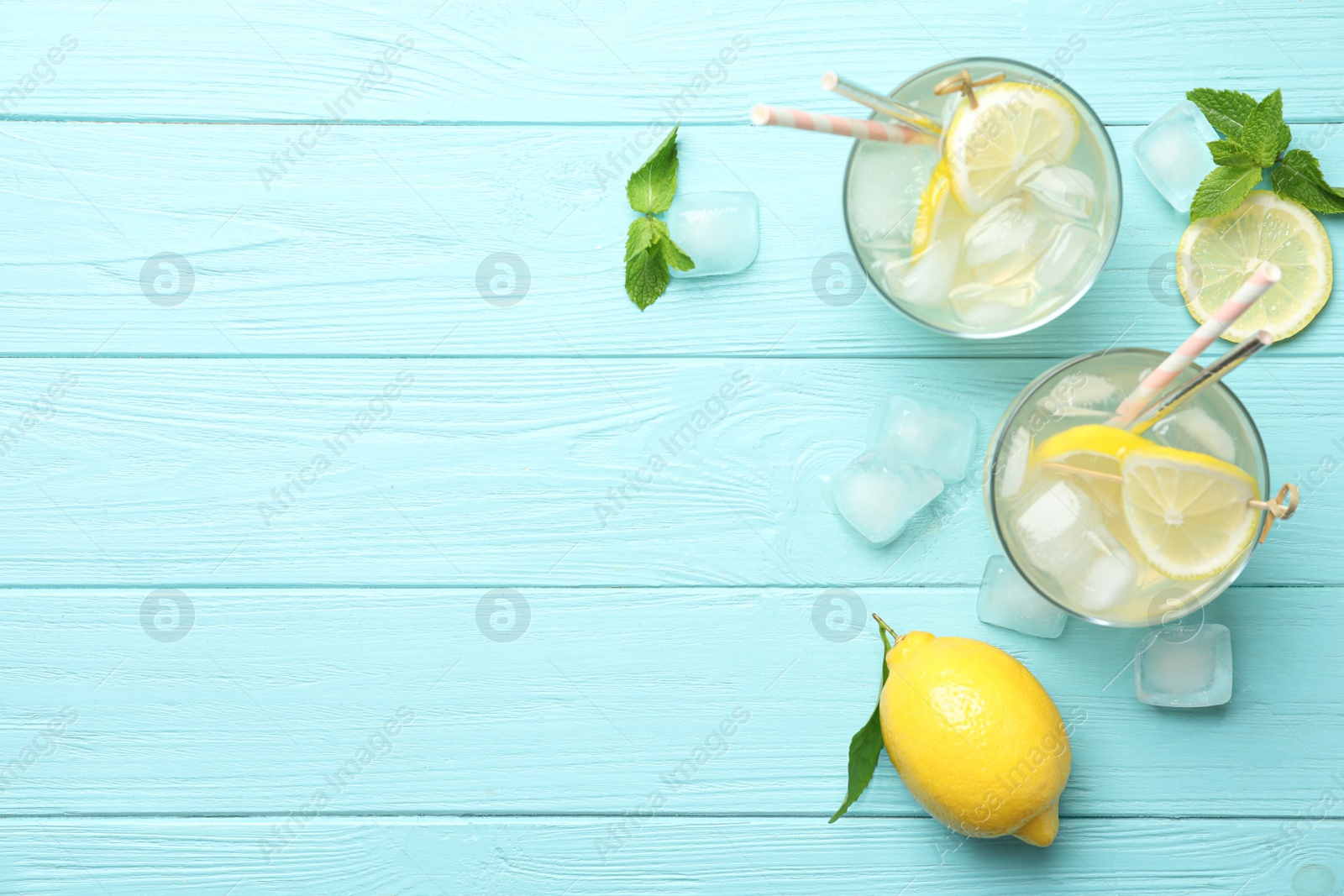 Photo of Natural lemonade and fresh fruit on light blue wooden table, flat lay with space for text. Summer refreshing drink