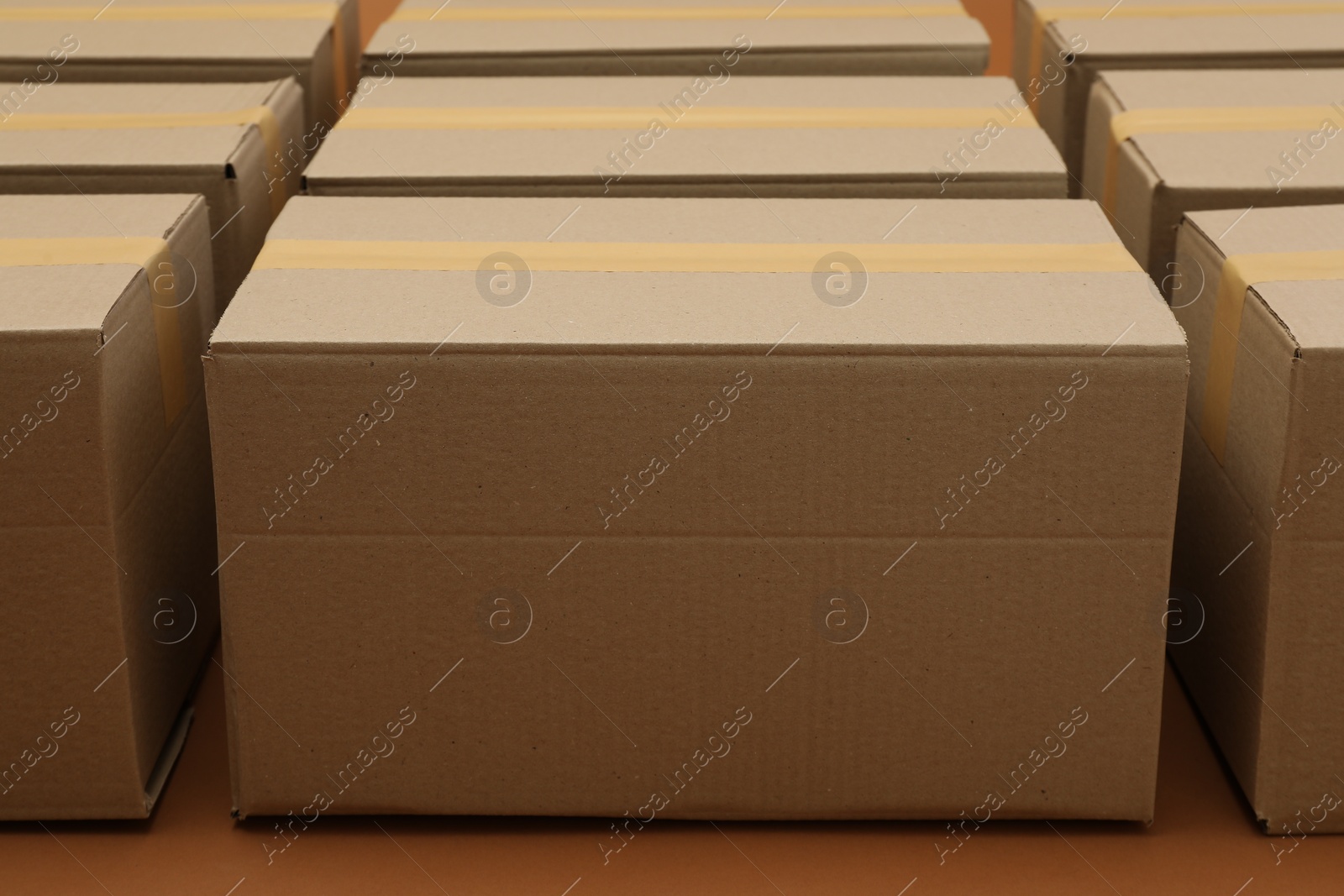 Photo of Many cardboard boxes on brown background, closeup