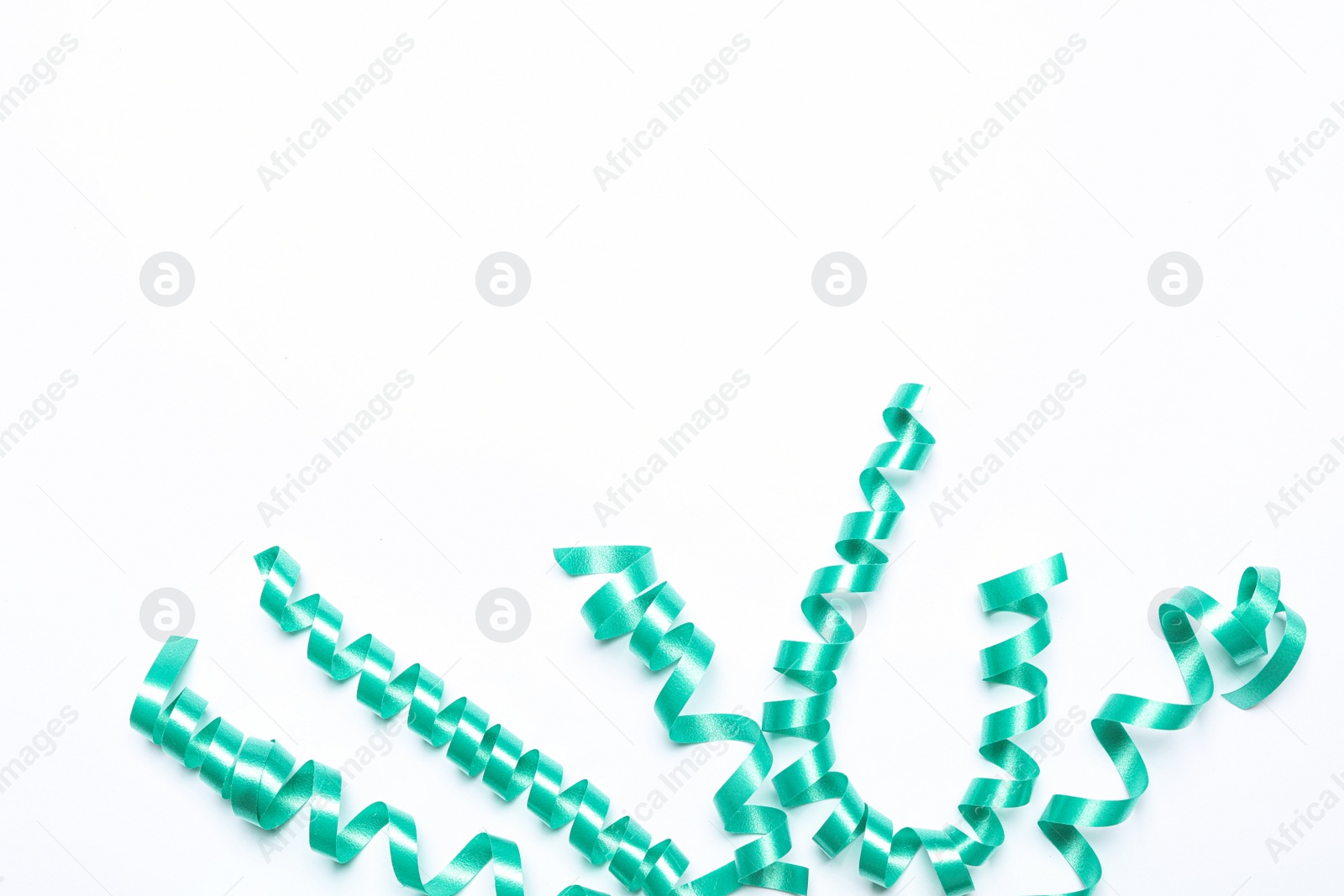 Photo of Turquoise serpentine streamers on white background, top view