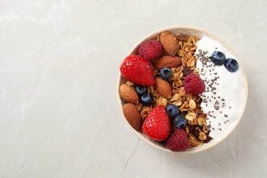 Photo of Tasty homemade granola served on marble table, top view with space for text. Healthy breakfast