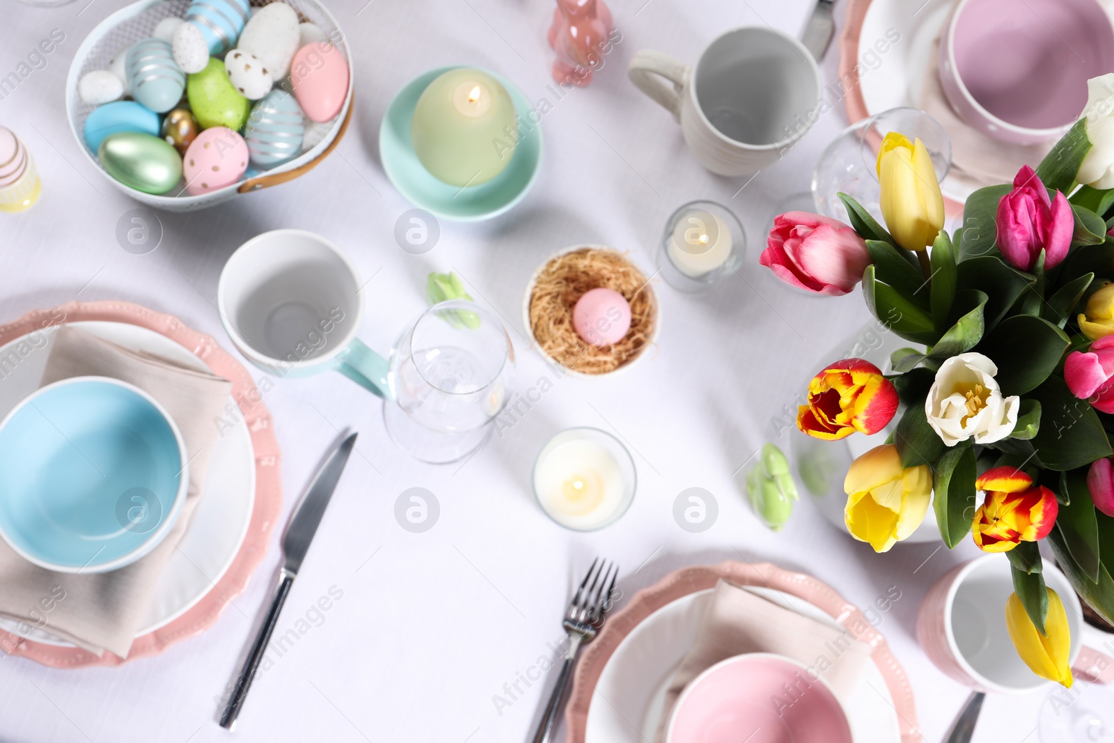 Photo of Festive table setting with beautiful flowers, flat lay. Easter celebration