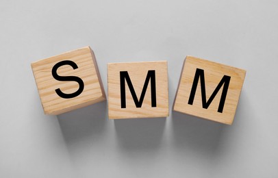 Photo of Cubes with abbreviation SMM (Social media marketing) on light grey background