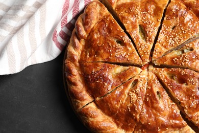 Photo of Cut delicious homemade pie on black table, top view