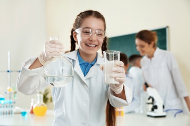 Schoolgirl making experiment in chemistry class, closeup
