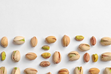 Photo of Composition with organic pistachio nuts on white background, top view. Space for text