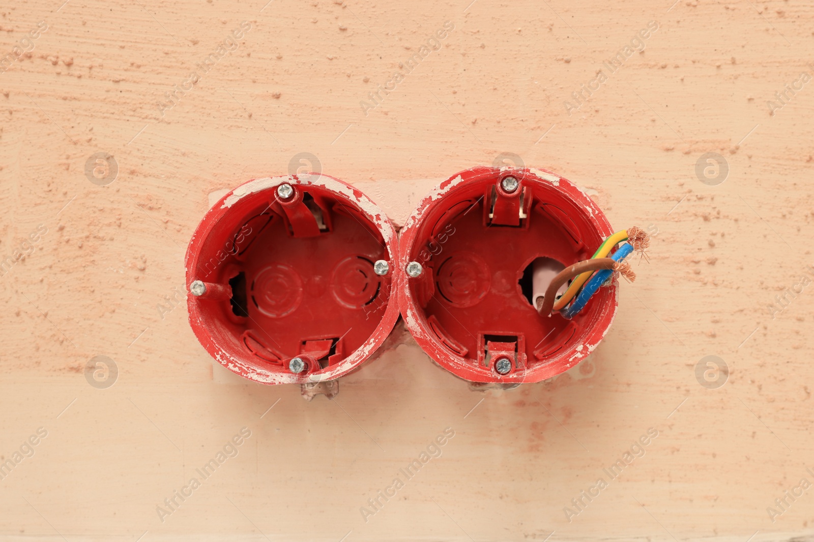 Photo of Mounting boxes with wires on wall, closeup