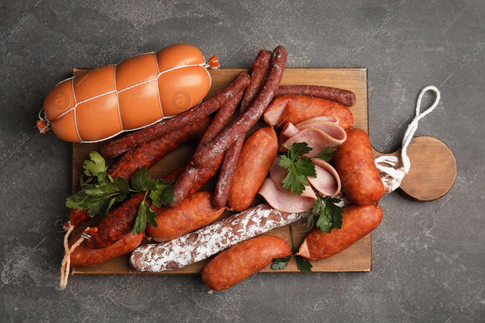 Photo of Different tasty sausages on grey table, top view