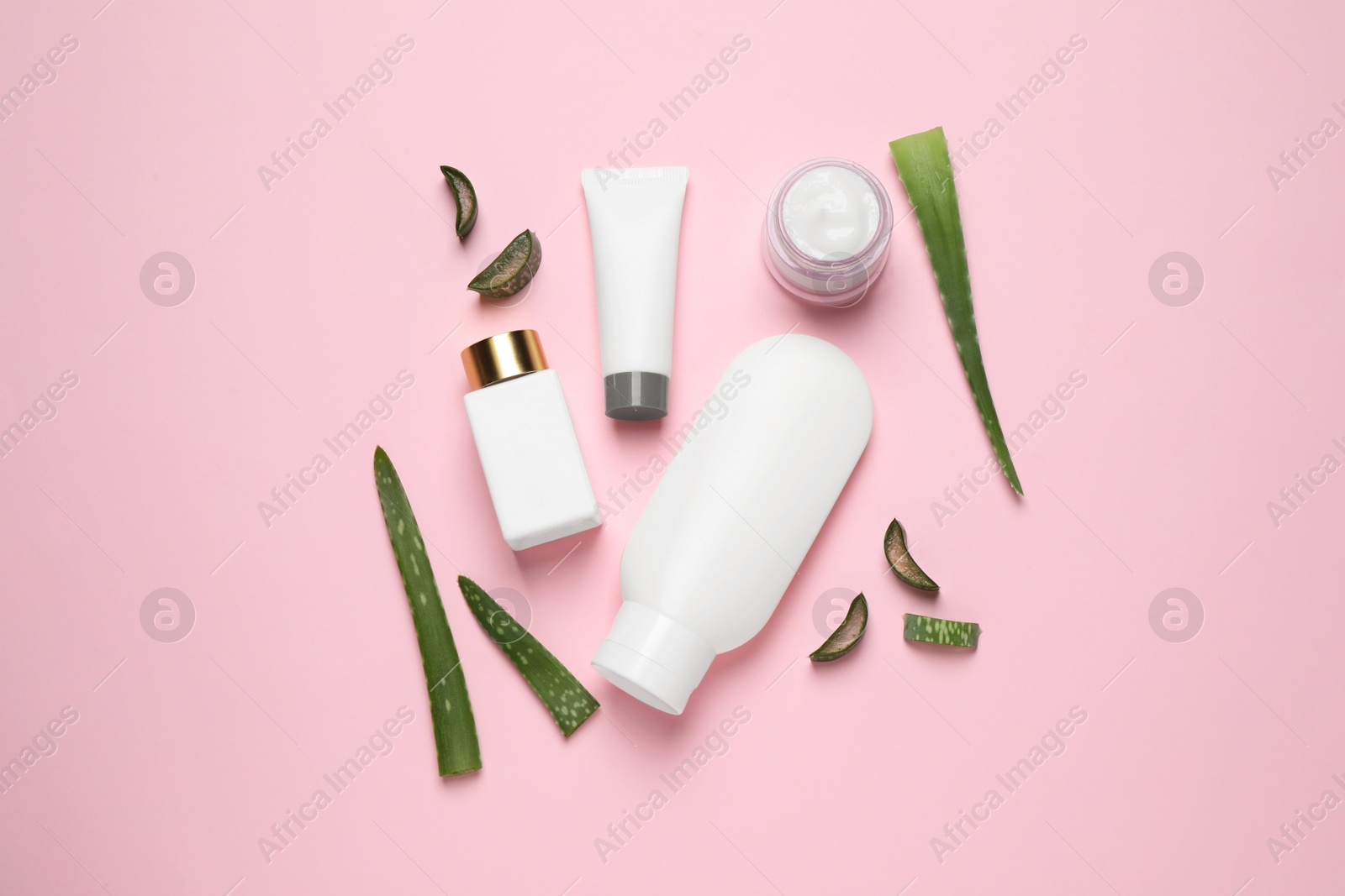 Photo of Flat lay composition with aloe vera and cosmetic products on pink background