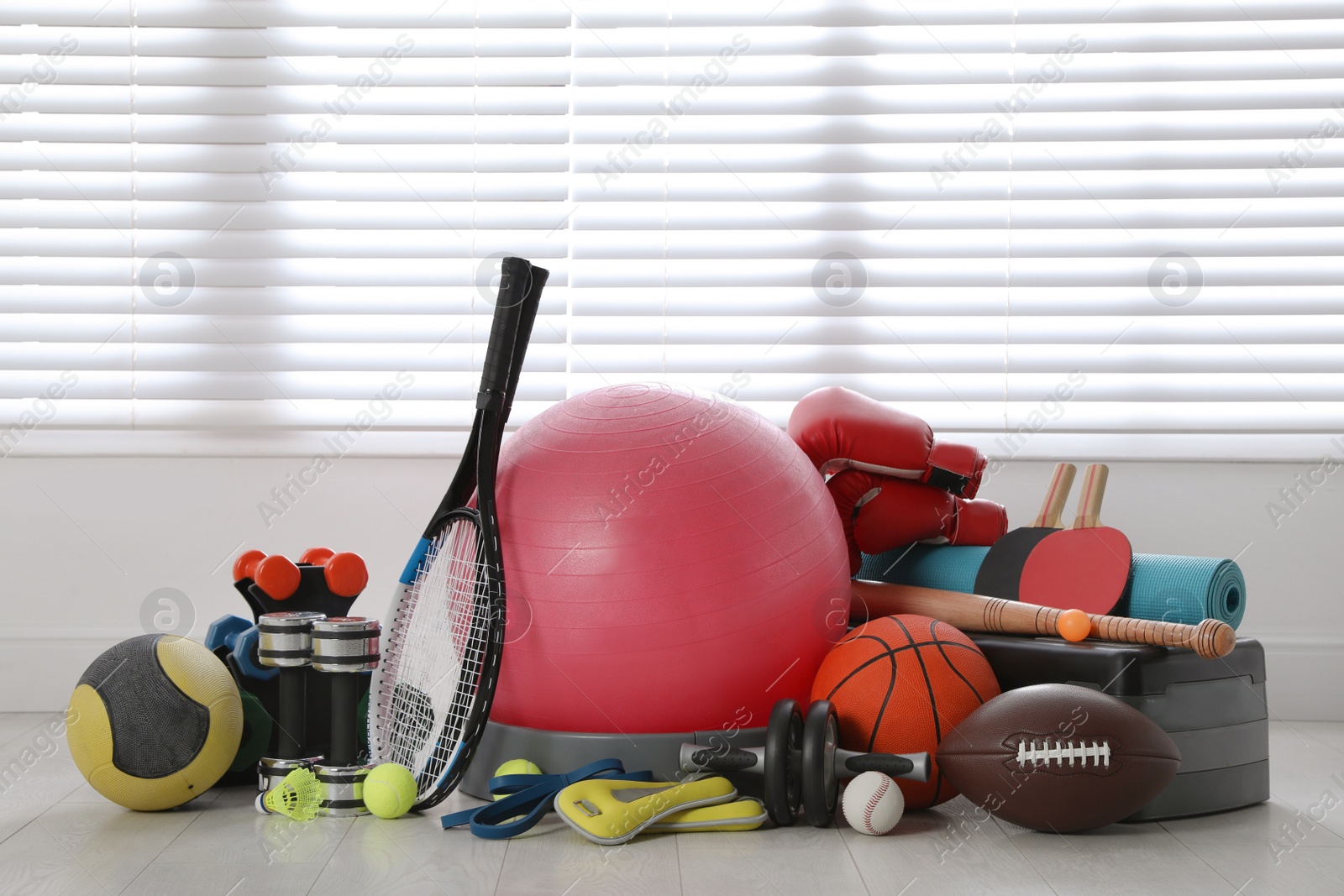 Photo of Set of different sports equipment on white floor indoors