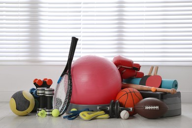 Photo of Set of different sports equipment on white floor indoors