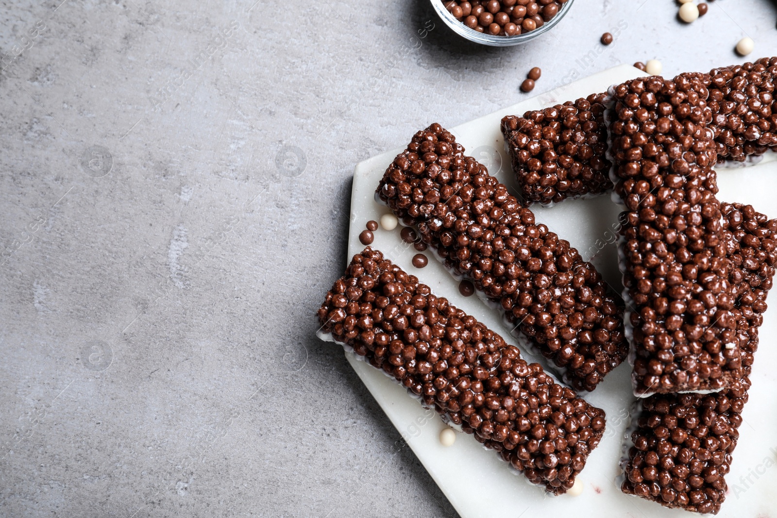 Photo of Delicious rice crispy treats on grey table, flat lay. Space for text