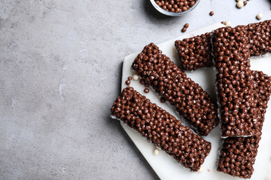 Photo of Delicious rice crispy treats on grey table, flat lay. Space for text