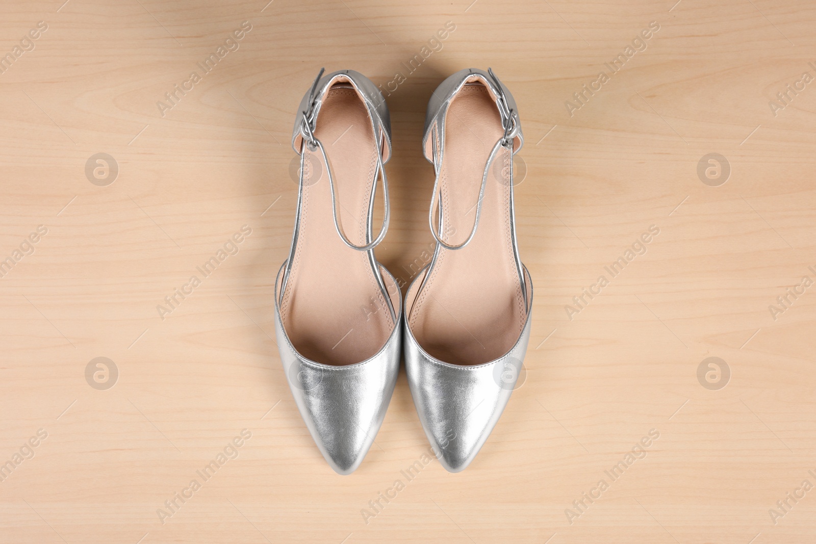 Photo of Pair of shoes on wooden background, top view