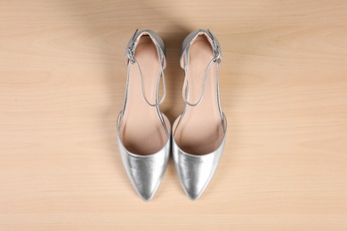 Photo of Pair of shoes on wooden background, top view