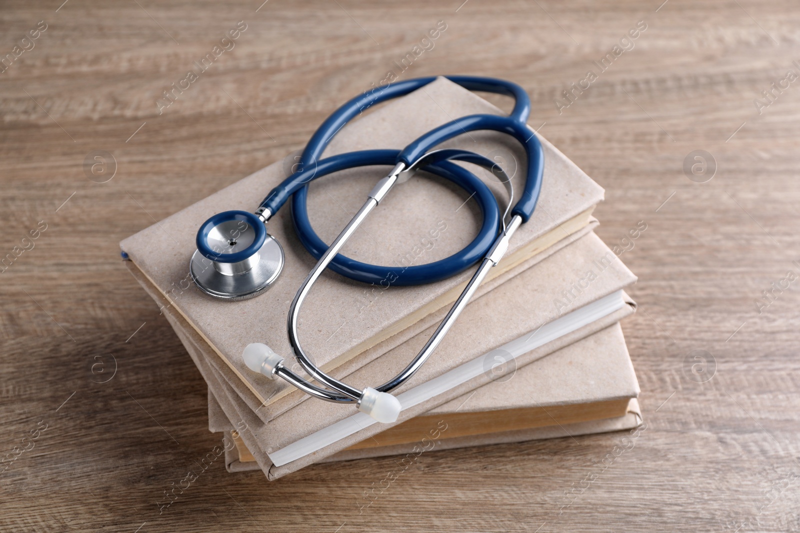 Photo of Student textbooks and stethoscope on wooden table. Medical education