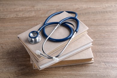 Photo of Student textbooks and stethoscope on wooden table. Medical education