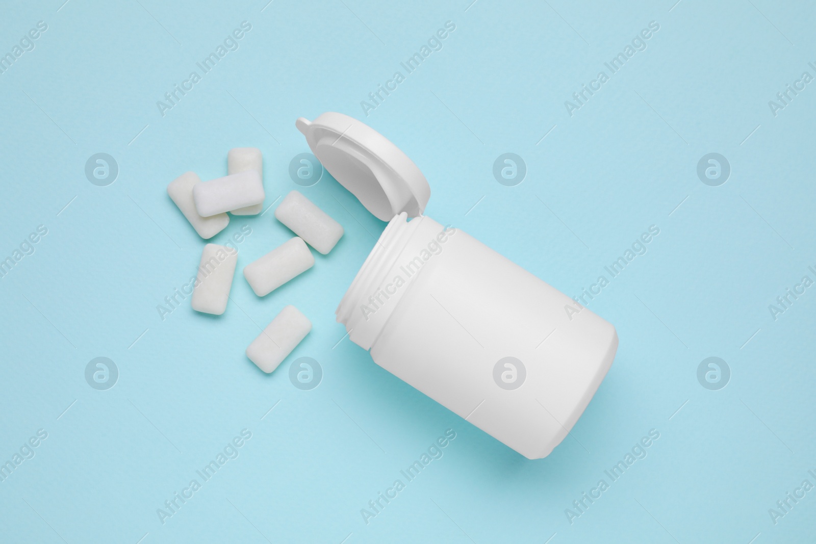 Photo of Jar with chewing gums on light blue background, flat lay