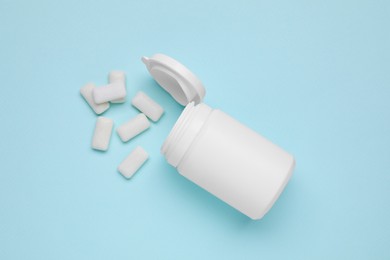 Photo of Jar with chewing gums on light blue background, flat lay