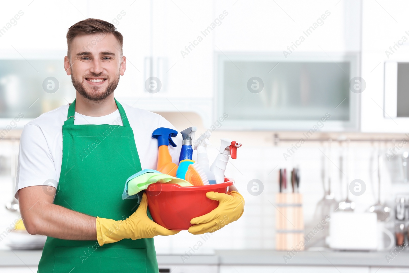 Photo of Man in uniform with cleaning supplies indoors