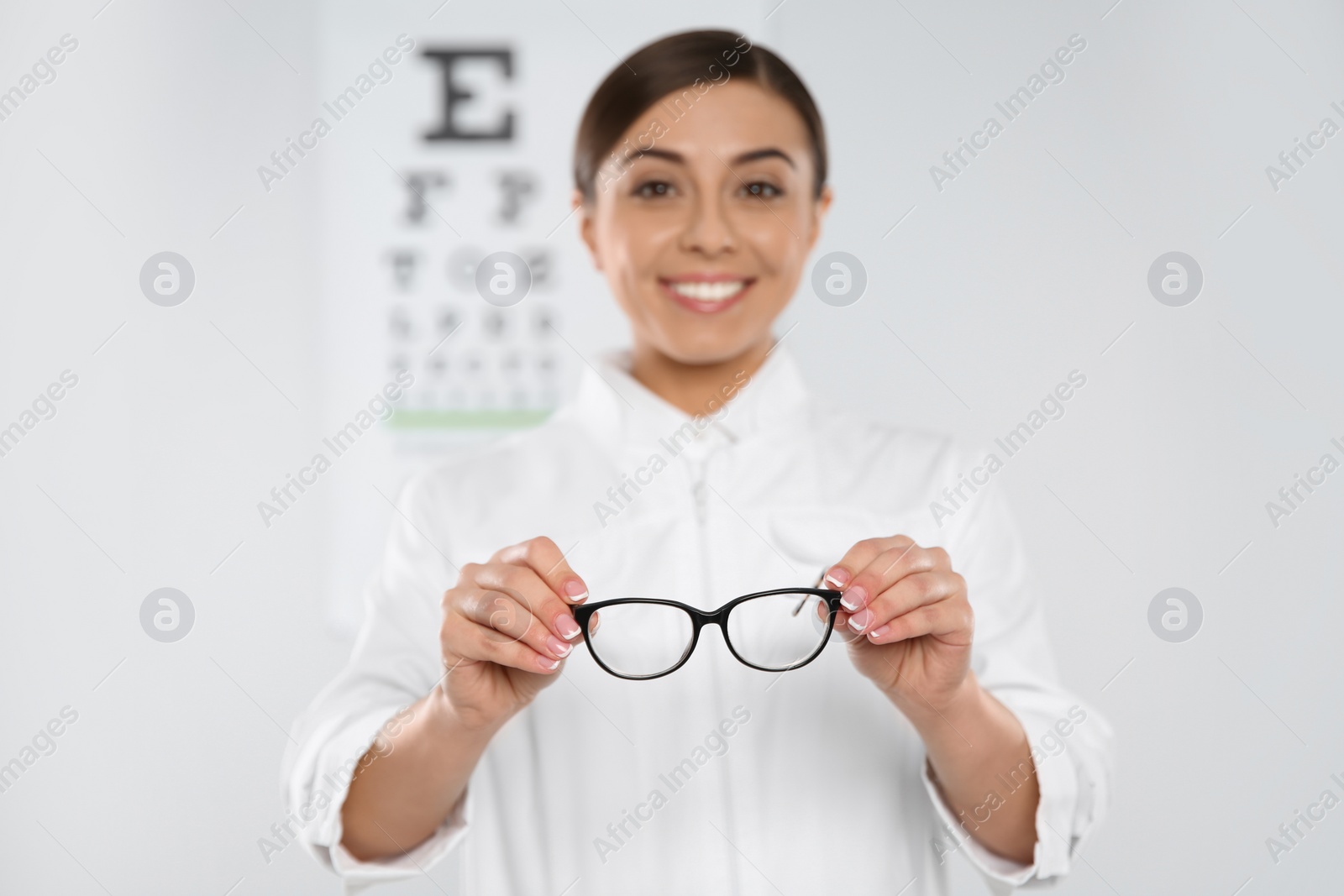 Photo of Female ophthalmologist with new eyeglasses in clinic