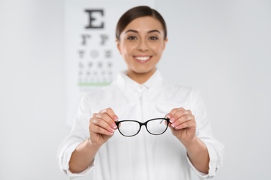 Female ophthalmologist with new eyeglasses in clinic