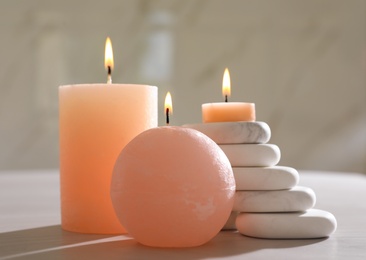 Photo of Composition with spa stones and candles on light wooden table