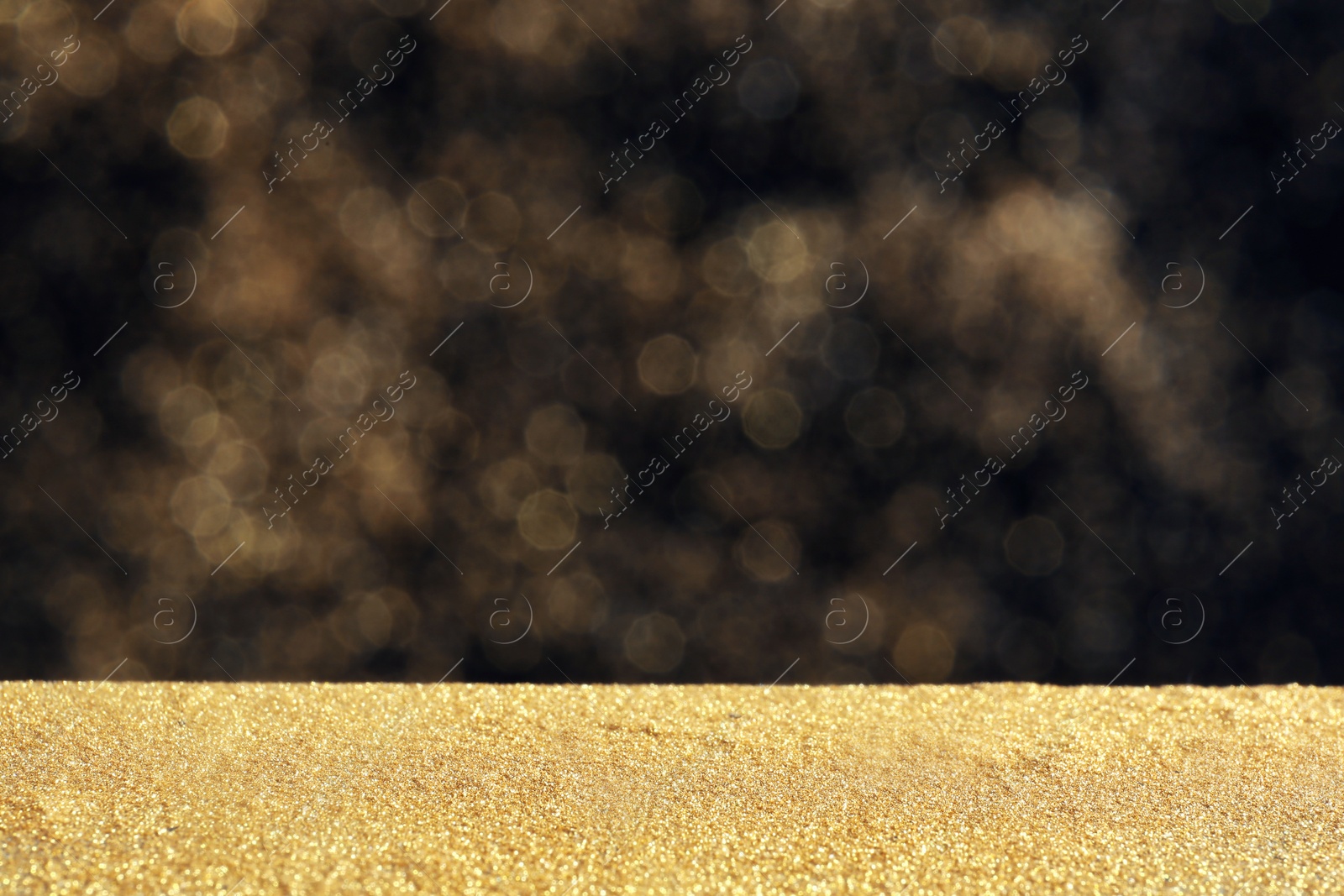 Photo of Glitter on table against dark background. Bokeh effect