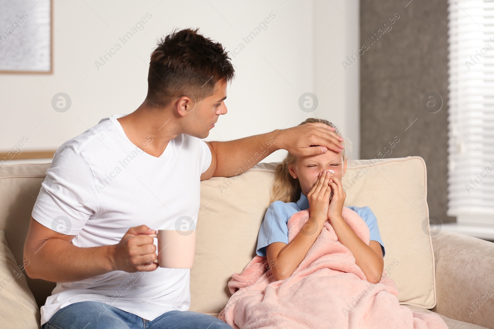 Photo of Father taking care of his sick daughter at home. Help concept