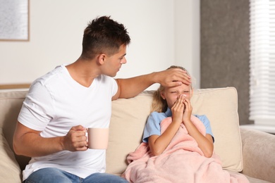 Father taking care of his sick daughter at home. Help concept